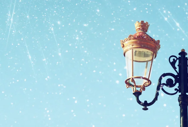 Picture of an antique street lamp against blue sky. vintage filtered image and bokeh lights. — Stock Photo, Image