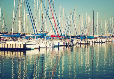 Romantic marina with yachts. retro filtered image clipart