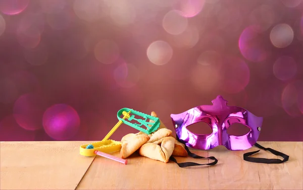 Hamantaschen biscotti o hamans orecchie, rumorista e maschera per la celebrazione Purim (festa ebraica) e sfondo glitter — Foto Stock