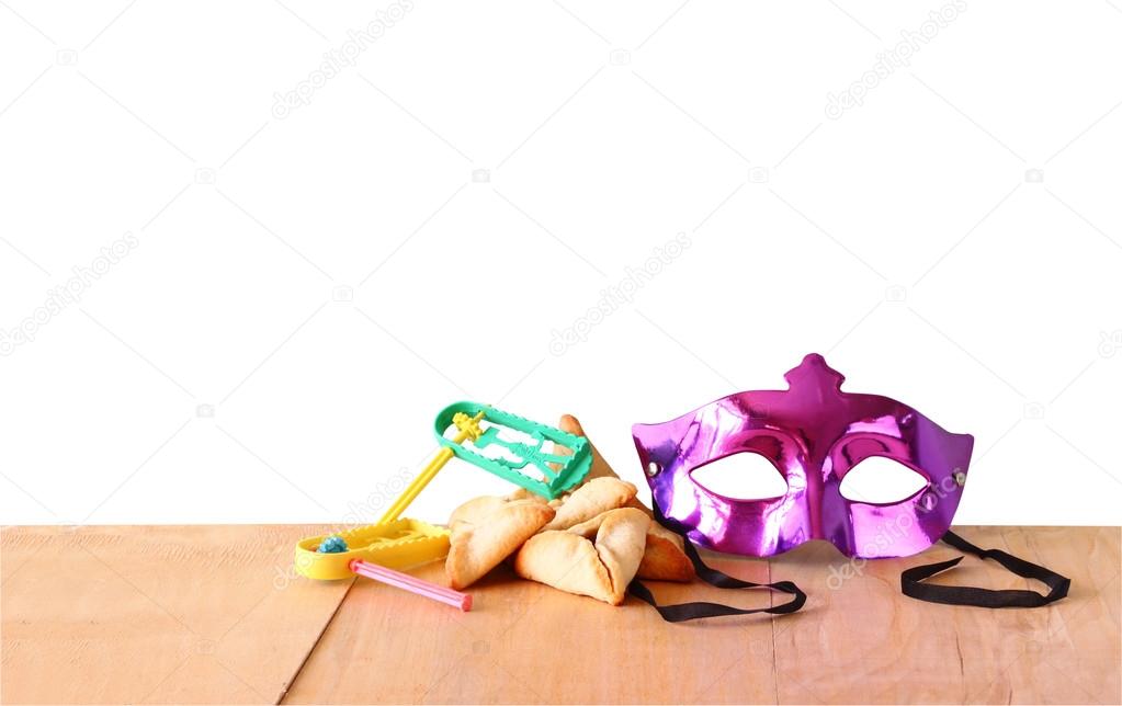 Hamantaschen cookies or hamans ears, noisemaker and mask for Purim celebration (jewish holiday) with isolated background