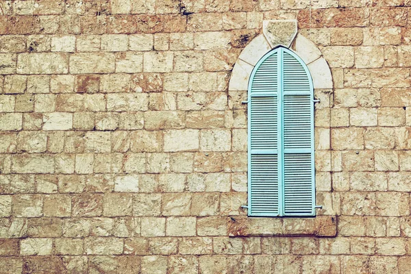 Alte Hauswand aus jerusalem Stein und alten blauen eisernen Fensterläden — Stockfoto