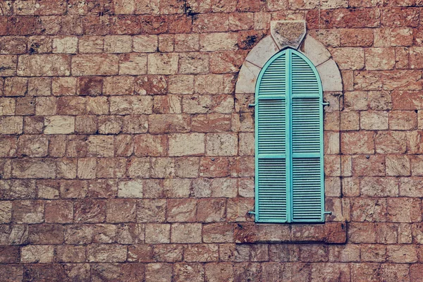 Alte Hauswand aus jerusalem Stein und alten blauen eisernen Fensterläden — Stockfoto