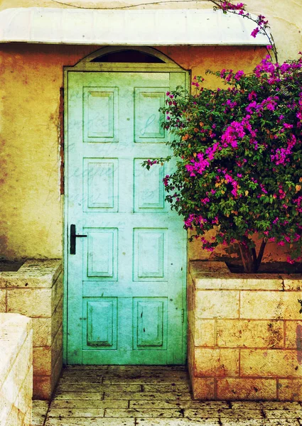 Old blue rustic wooden door and flowers. filtered image with texture overlay — Stock Photo, Image