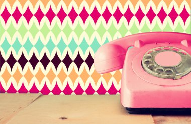 Ahşap masa ve soyut retro geometrik Model arka plan Retro pastel pembe telefon. Retro filtre uygulanmış görüntü