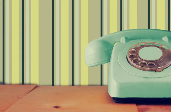 Retro pastelowych mięta telefon na drewnianym stole i streszczenie geometryczne retro pastelowy wzór tła. retro filtrowanego obrazu — Zdjęcie stockowe