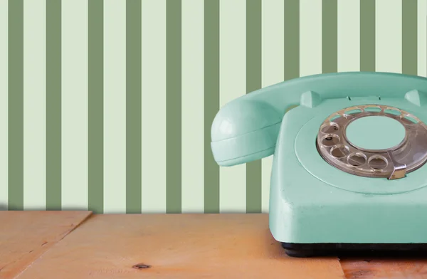 Retro pastelowych mięta telefon na drewnianym stole i streszczenie geometryczne retro pastelowy wzór tła. retro filtrowanego obrazu — Zdjęcie stockowe