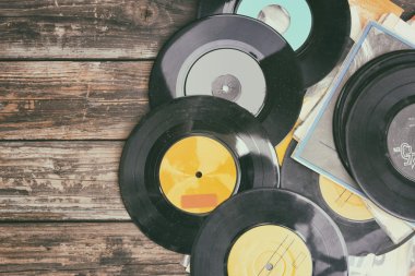 Close up image of old records over wooden table , image is retro filtered .