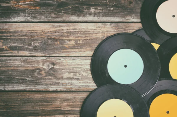 Close up image of old records over wooden table, image is retro filtered  . — стоковое фото