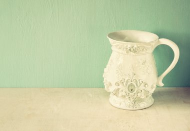 Beyaz klasik ve antika vazo ahşap masa üzerinde. Filtre uygulanmış görüntü