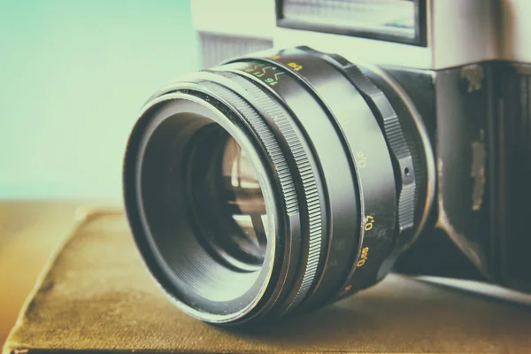 Cerca de la foto de la lente de la cámara vieja sobre la mesa de madera. imagen se filtra retro. enfoque selectivo — Foto de Stock