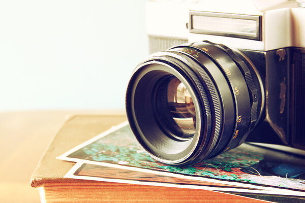 Close up photo of old camera lens over wooden table. image is retro filtered. selective focus