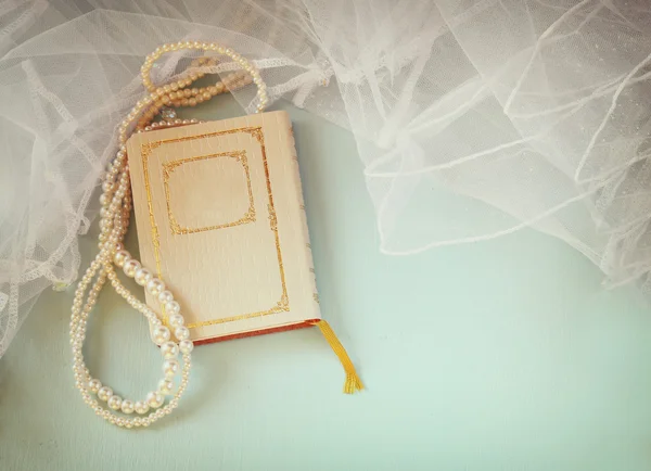 Vue du dessus de vieux livre et collier femme sur table en bois . — Photo