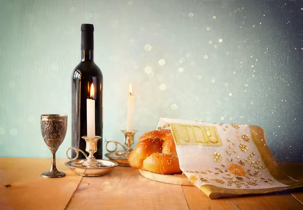 Sabbatbild. Challah-Brot und Kerzenleuchter auf einem Holztisch. Glitzerüberzug — Stockfoto