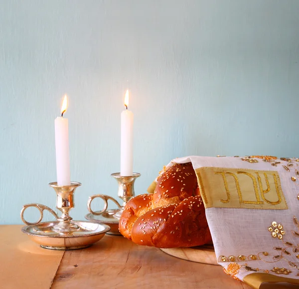 Shabbat Shalom challah bread, shabbat wine and candles on wooden