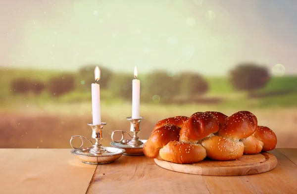 Afbeelding van de Sabbat. Galle brood en candela op houten tafel — Stockfoto