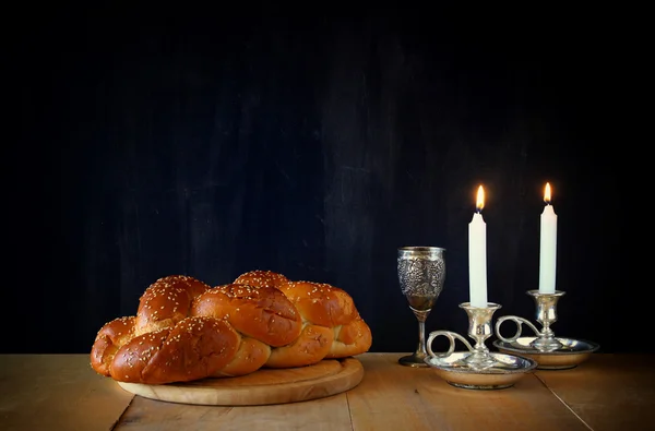 Sabbatbild. Challahbrot und Kerzenlichter auf Holztisch — Stockfoto