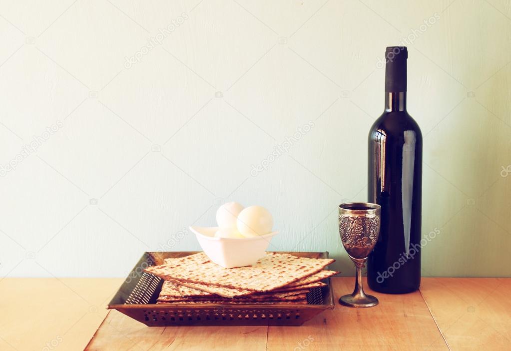 Passover background. wine and matzoh (jewish passover bread) over wooden background.