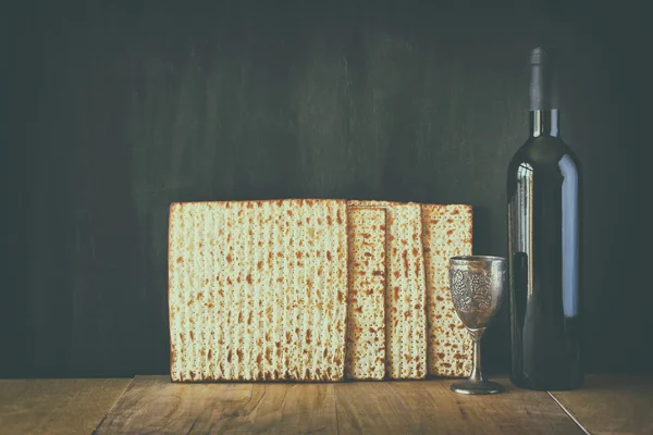 Sfondo pasquale. vino e matzoh (pane pasquale ebraico) su sfondo di legno. immagine è filtrata con stile retrò sbiadito — Foto Stock