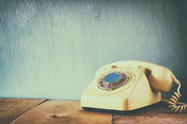 Retro telefon na drewnianym stole. filtrowanego obrazu z wyblakłe w stylu retro — Zdjęcie stockowe