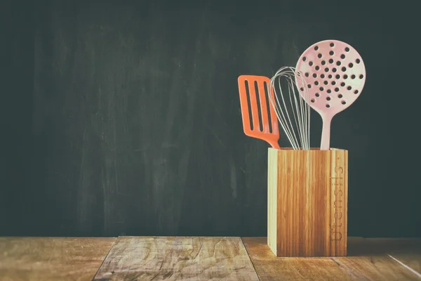 Kitchen utensils over wooden textured background — Stock Photo, Image