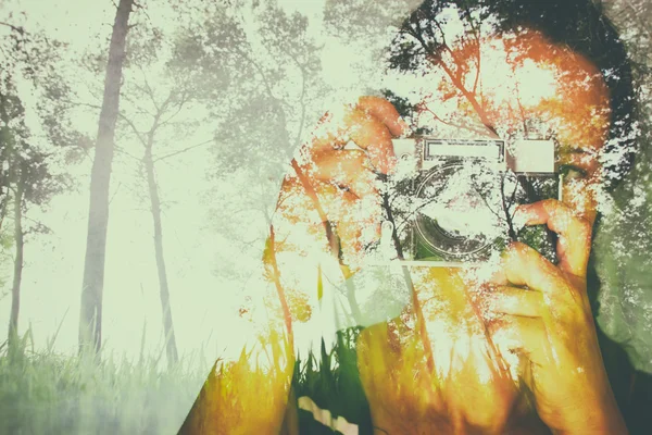 Double exposure image of young girl holding old camera and nature background — Stock Photo, Image