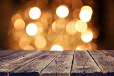 Rustic wood table in front of glitter gold bright bokeh lights