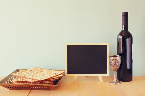 Пасхальный фон. вино и маца (еврейский пасхальный хлеб) на деревянном фоне . — стоковое фото