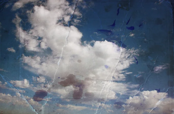 Sepia toned image of clouds in te sky. image is textured with paper texture and stains, vintage look style — Stock Photo, Image