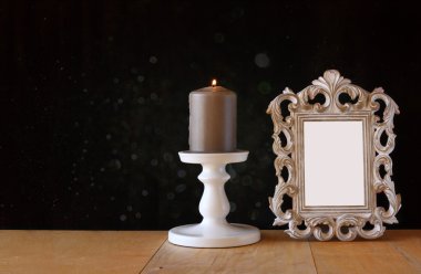 Dokulu görüntü vintage antik klasik çerçeve ve yanan mum ahşap masa ve siyah arka plan