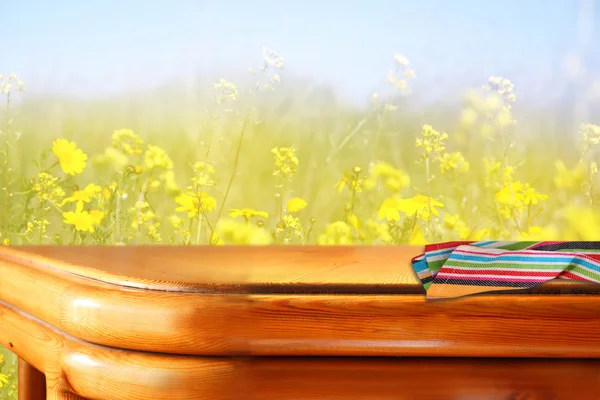 Wood board table in front of summer landscape with double exposure of flower field bloom