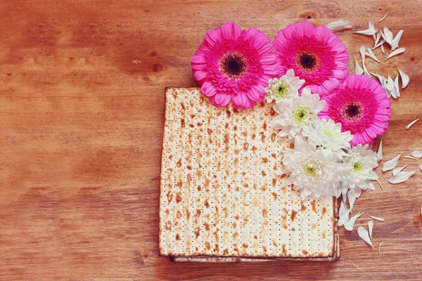 Fısıh arka plan. matzoh (Yahudi Fısıh ekmek) ve ahşap masaya çiçek — Stok fotoğraf