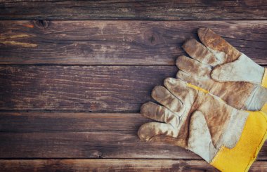 Yıpranmış iş eldivenleri ve çeşitli iş araçları ahşap arka plan üzerinde Üstten Görünüm