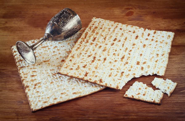 Пасхальний фон. винна чашка та мацо (єврейський хліб на пасху) на дерев'яному фоні . — стокове фото