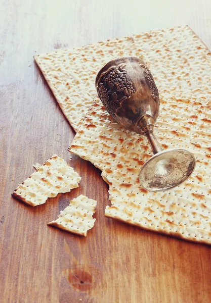 Пасхальный фон. Кубок вина и matzoh (еврейский пасхальный хлеб) на деревянном фоне . — стоковое фото