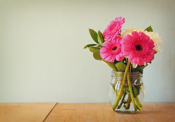 Buquê de flores de verão na mesa de madeira com fundo de hortelã. imagem filtrada vintage — Fotografia de Stock