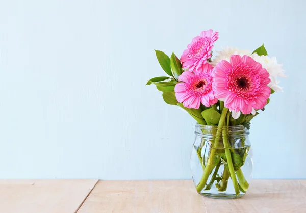 夏ミントの背景を持つ木製のテーブルの上に花の花束。ビンテージのフィルターされたイメージ — ストック写真