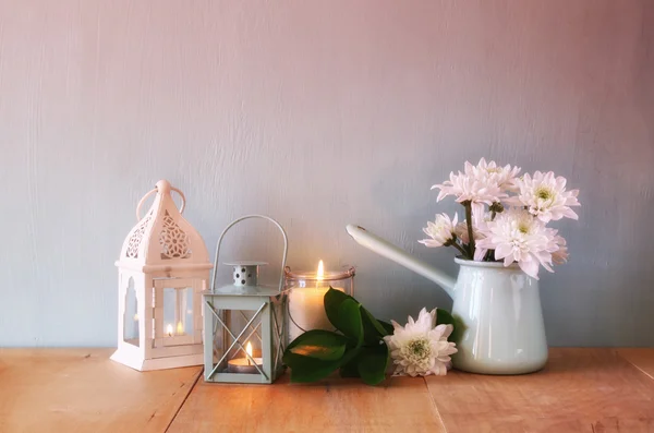 Ramo de flores de verano y linterna vintage en la mesa de madera con luz romántica por la noche. vintage imagen filtrada — Foto de Stock