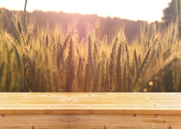 Wood board table in front of field of wheat on sunset light. Ready for product display montages — Stock Photo, Image