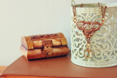 Ahşap masa üzerinde antik vintage kolye. Retro filtre uygulanmış görüntü