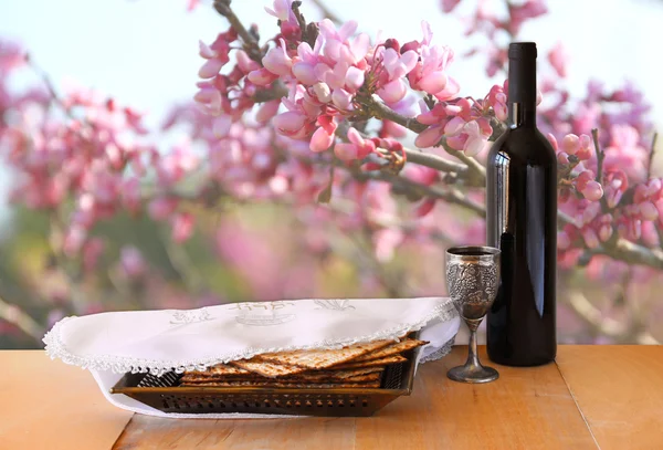 Sfondo pasquale. vino e matzoh (pane pasquale ebraico) sulla tavola di legno — Foto Stock