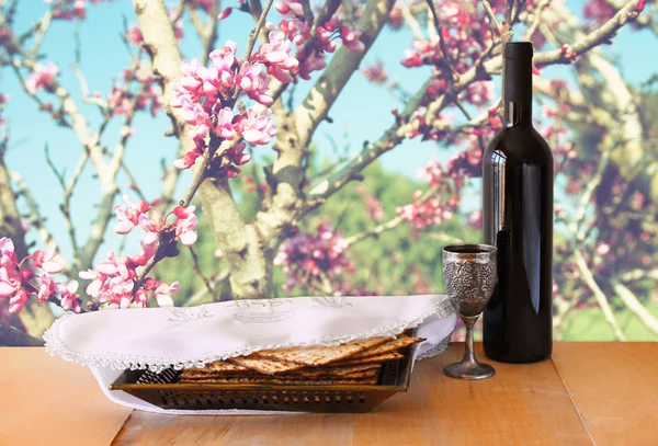 Sfondo pasquale. vino e matzoh (pane pasquale ebraico) sulla tavola di legno — Foto Stock