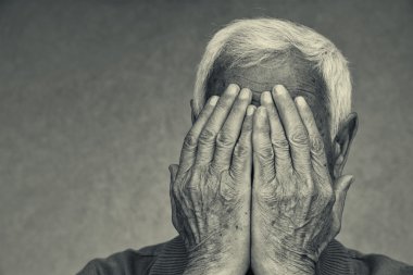 Yüzünü elleriyle kapsayan üst düzey adam portresi. siyah beyaz resim