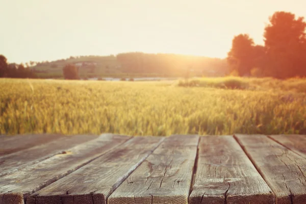 Дерев'яна дошка столу перед полем пшениці на світлі заходу сонця. Готовий до установки дисплея продукту — стокове фото