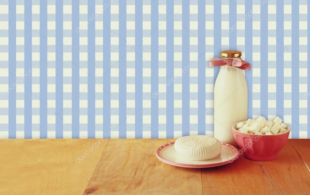 Greek cheese , bulgarian cheese and milk on wooden table over rustic background. Symbols of jewish holiday - Shavuot