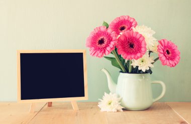 Yaz buket çiçek ahşap masa ve blackboard nane arka plan ile metin için yer ile. Vintage filtre uygulanmış görüntü