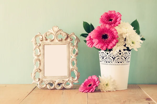 Bouquet estivo di fiori e cornice vittoriana sul tavolo in legno con sfondo menta. immagine filtrata vintage — Foto Stock