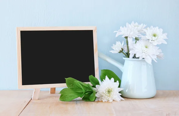 Summer bouquet of flowers on the wooden table and blackboard with room for text with mint background. vintage filtered image — Stock Photo, Image