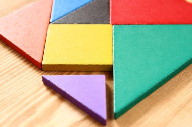 Ahşap masa üzerinde bir kare tangram bulmacanın kayıp bir parça.