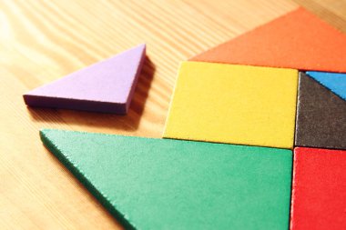 Ahşap masa üzerinde bir kare tangram bulmacanın kayıp bir parça.
