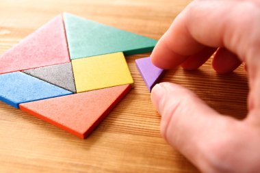 Ahşap masa üzerinde bir kare tangram bulmacanın kayıp bir parça.